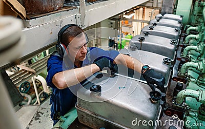 Marine engineer officer controlling vessel enginesand propulsion in engine control room ECR Stock Photo
