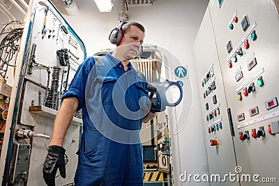 Marine engineer officer controlling vessel enginesand propulsion in engine control room ECR Stock Photo