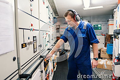 Marine engineer officer in engine control room ECR. He works in workshop Stock Photo