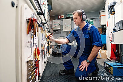 Marine engineer officer in engine control room ECR. He works in workshop Stock Photo
