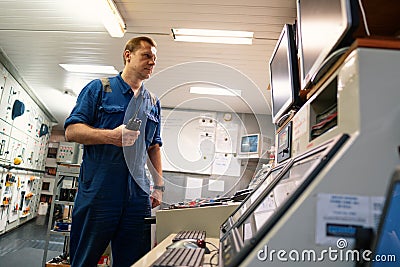 Marine Engineer working on radio communication at Engine Control room ECR Stock Photo