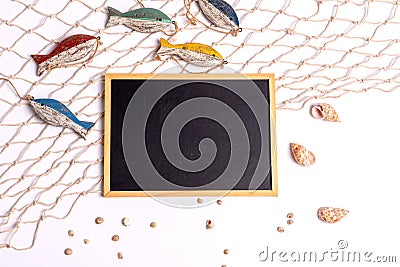 Marine still life: an empty board on a sea net, wooden fish and seashells on a white background Stock Photo