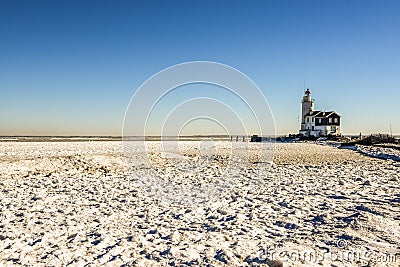 The lighthouse of Marken, `het Paard van Marken` in winter and the frozen Markermeer, Holland Stock Photo