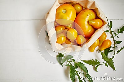 Market delivary of yellow tomatoes in eco textile bag, Zero waste Stock Photo