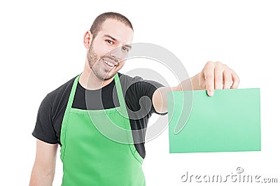 Market employee showing green cardboard and smiling Stock Photo