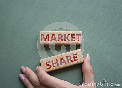 Market Share symbol. Wooden blocks with words Market Sharer. Beautiful grey green background. Businessman hand. Business and Stock Photo