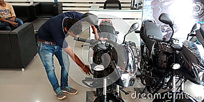 marketing staff displaying motorcycle latest model into the bajaj showroom in India Editorial Stock Photo