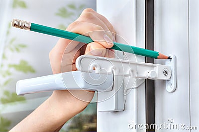 Marking holes for fixing tilt restrictor PVC window. Stock Photo
