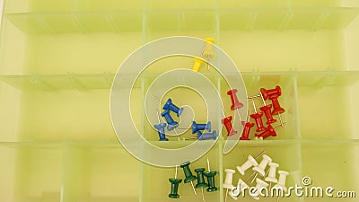 Marking pins in various colors, in green plastic box with divisions Stock Photo