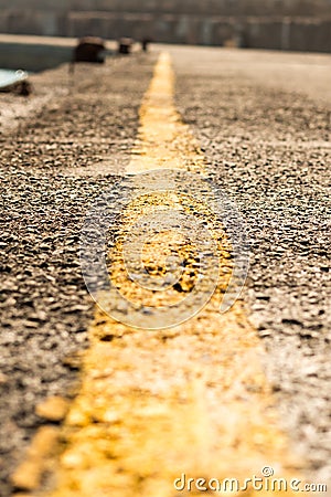 Marking separating yellow stripe road, label extending far close-up. Perspective vertical photo yellow strip road Stock Photo