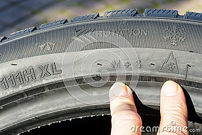 Markings on the sidewall of a new winter tire, speed, load, rotation, mud and snow designations Stock Photo