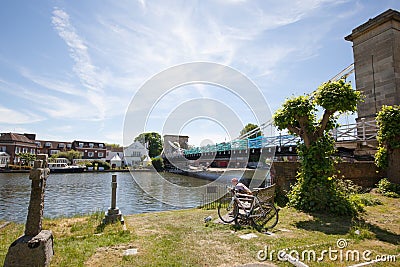 A cyclist resting at Marlow Bridge by The Thames River in Marlow, Buckinghamshire, UK Editorial Stock Photo