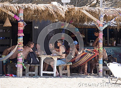 Marmari, Evia island, Greece. August 2020: Holidaymakers and tourists relax on beach loungers and in cafes on the beach on the Gre Editorial Stock Photo