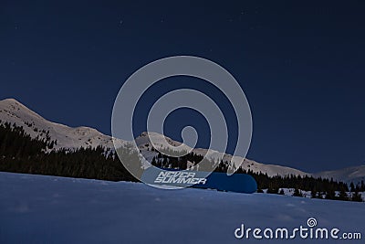 Never Summer snowboard in snowy mountains under bright night stars Editorial Stock Photo