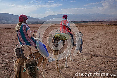 Marrakech, Morocco - Feb 22, 2023: Tourists ride Dromedary camels through the Agafay desert Editorial Stock Photo