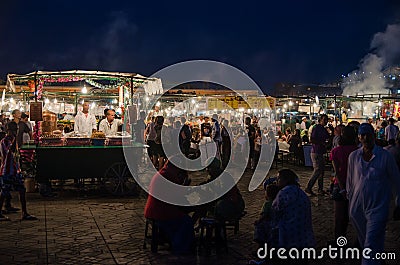 Marrakesh, Morocco - September 05 2013: Food stands with smoke and light on famous Jamaa el Fna square in evening Editorial Stock Photo