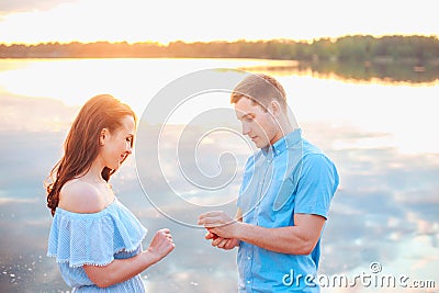 Marriage proposal on sunset . young man makes a proposal of betrothal to his girlfriend on the beach Stock Photo