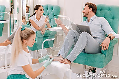 Married couple communicating while enjoying feet massage Stock Photo