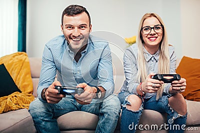 Married couple playing video games on general gaming console. Details of modern lifestyle with couple having fun Stock Photo