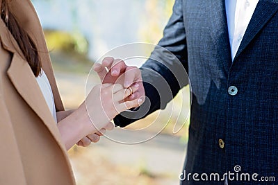 Marry me today and every day, hands of a wedding heterosexual couple. The groom put the ring on the finger of his beautiful wife. Stock Photo