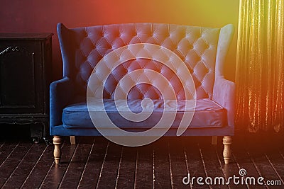 Marsala wall, golden curtain and vintage upholstered blue sofa Stock Photo