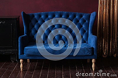 Marsala wall, golden curtain and vintage upholstered blue sofa Stock Photo