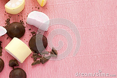 Marshmallows and chocolate on pink background with copy space. Wallpaper texture of colorful marshmellow and sweets. Stock Photo