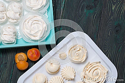 Marshmallows laid out on a tray. Nearby are ripe apricots Stock Photo