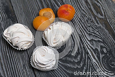 Marshmallows laid out on a tray. Nearby are ripe apricots Stock Photo