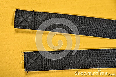 Martial art black belt isolated on yellow mat background Stock Photo