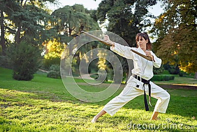 Martial arts teacher in white kimono is practicing with tonfa. Stock Photo