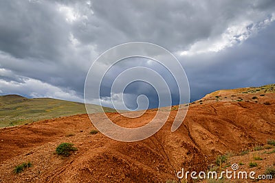 Martian landscape, natural landmark of Altai Republic. Mountains colored red, yellow, and orange against a blue sky with white Stock Photo