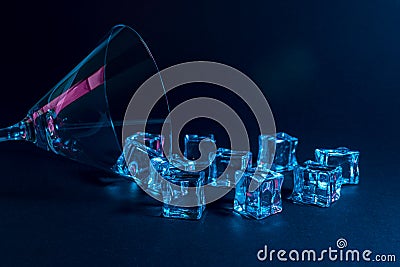 Martini glass with ice cubes in neon holographic vibrant pink and blue colors. Minimal celebration concept Stock Photo