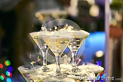 Martini glasses in the form of a cascade or pyramid lit light at the wedding party Stock Photo