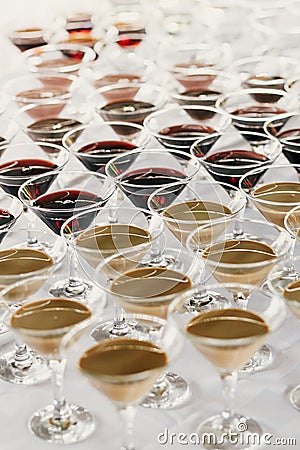 Martini rows on table at wedding reception. Cocktails and red and white martini in glasses at alcohol bar at wedding or christmas Stock Photo