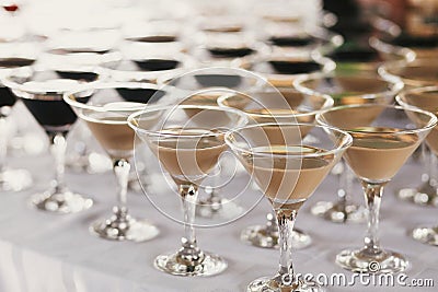 Martini rows on table at wedding reception. Cocktails and red and white martini in glasses at alcohol bar at wedding or christmas Stock Photo