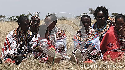 MASAI MARA, КЕНИЯ 26-ОЕ СЕНТЯБРЯ 2016: женщины maasai на выпускном дне школы koiyaki направляя в Кении видеоматериал MASAI MARA, КЕНИЯ 26-ОЕ СЕНТЯБРЯ 2016: женщины maasai на выпускном дне школы koiyaki направляя в Кении видеоматериал