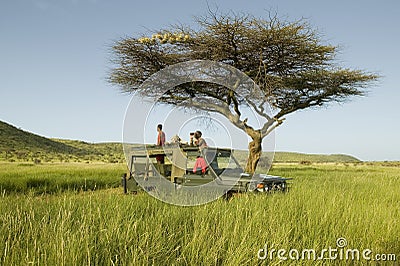 Masai scouts and tourist look for animals from a Landcruiser during a game drive at the Lewa Wildlife Conservancy in North Kenya, Editorial Stock Photo