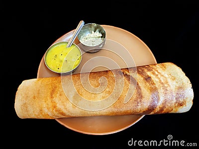 Masala dosa served with sambar and chutney in a brown plate Stock Photo