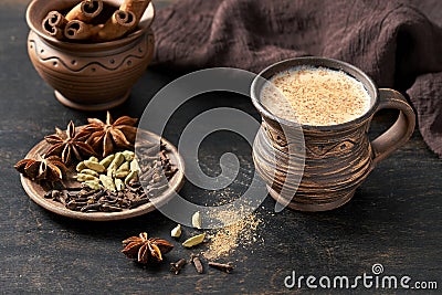 Masala pulled tea chai latte hot Indian sweet milk spiced drink, cinnamon stick, cloves, fresh spices and herbs blend Stock Photo