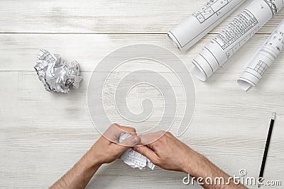 Masculine hands tearing a bad architect drawing to the pieces. Nervous condition. Stock Photo