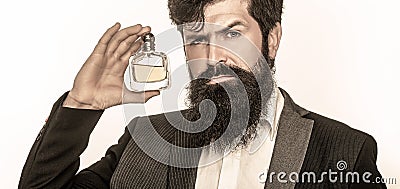 Masculine perfume, bearded man in a suit. Male holding up bottle of perfume. Closeup portrait. Perfume or cologne bottle Stock Photo