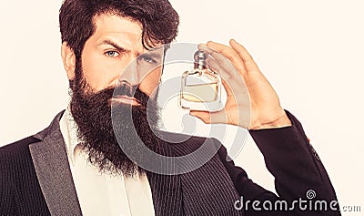 Masculine perfume, bearded man in a suit. Male holding up bottle of perfume. Perfume or cologne bottle, perfumery Stock Photo