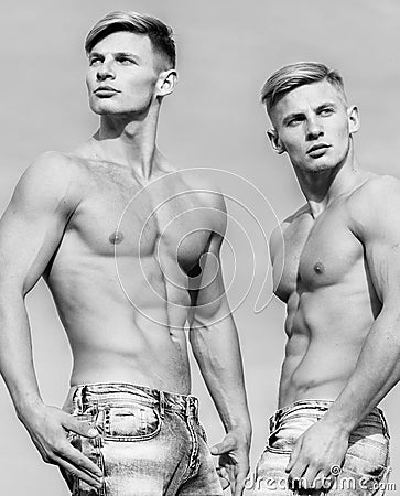Masculinity concept. Men twins brothers muscular guys sky background. Men strong muscular athlete bodybuilder Stock Photo