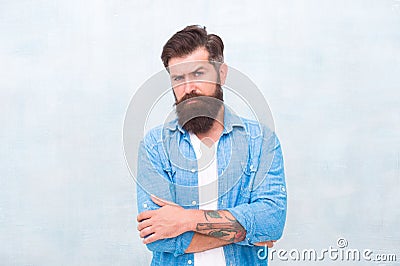 Masculinity and male beauty concept. Well groomed macho. Brutal handsome hipster man on grey wall background. Bearded Stock Photo