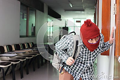 Masked burglar escaping after sneaking into the house. Crime concept Stock Photo