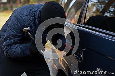 Masked burglar with hammer Stock Photo