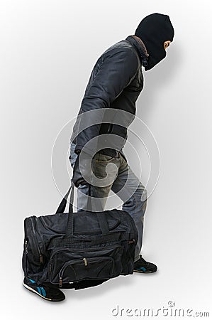 Masked burglar or thief with balaclava is sneaking with black ba Stock Photo