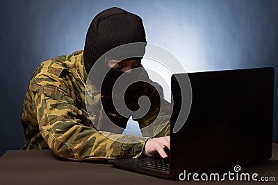 Masked cyber terrorist hacking army intelligence Stock Photo