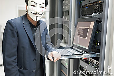 Masked Hacker in Computer Server room Concept . Editorial Stock Photo
